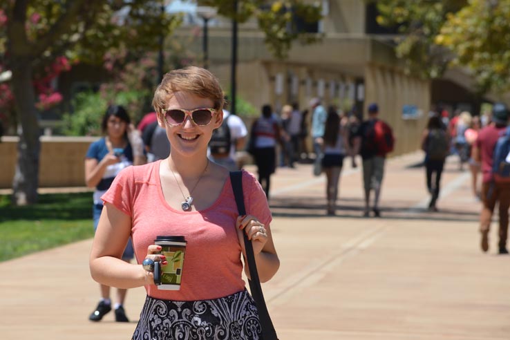 A student holding a cup of coffee.